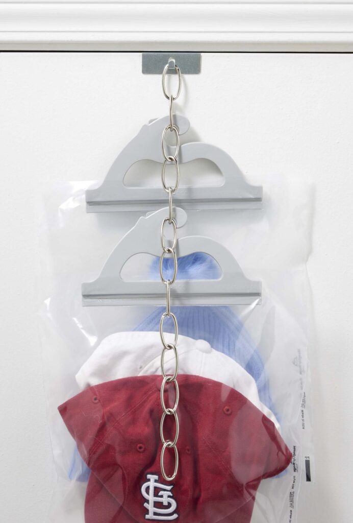 Over top of standard door metal bracket to hang multi-use see-thru poly storage bags